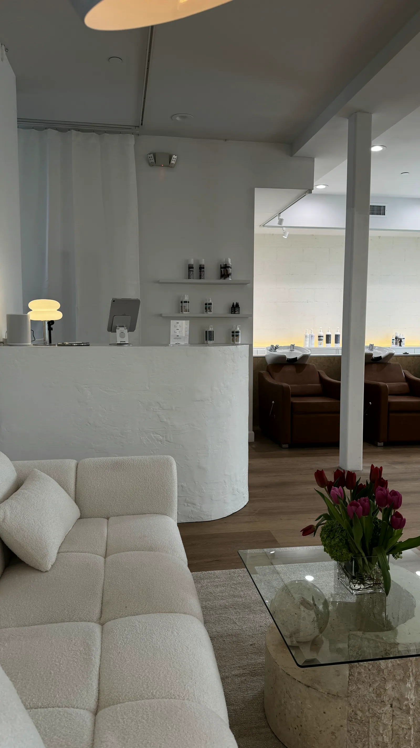 The reception desk at Blonde Voyage Temecula, with TRVL Haircare on the shelves behind it